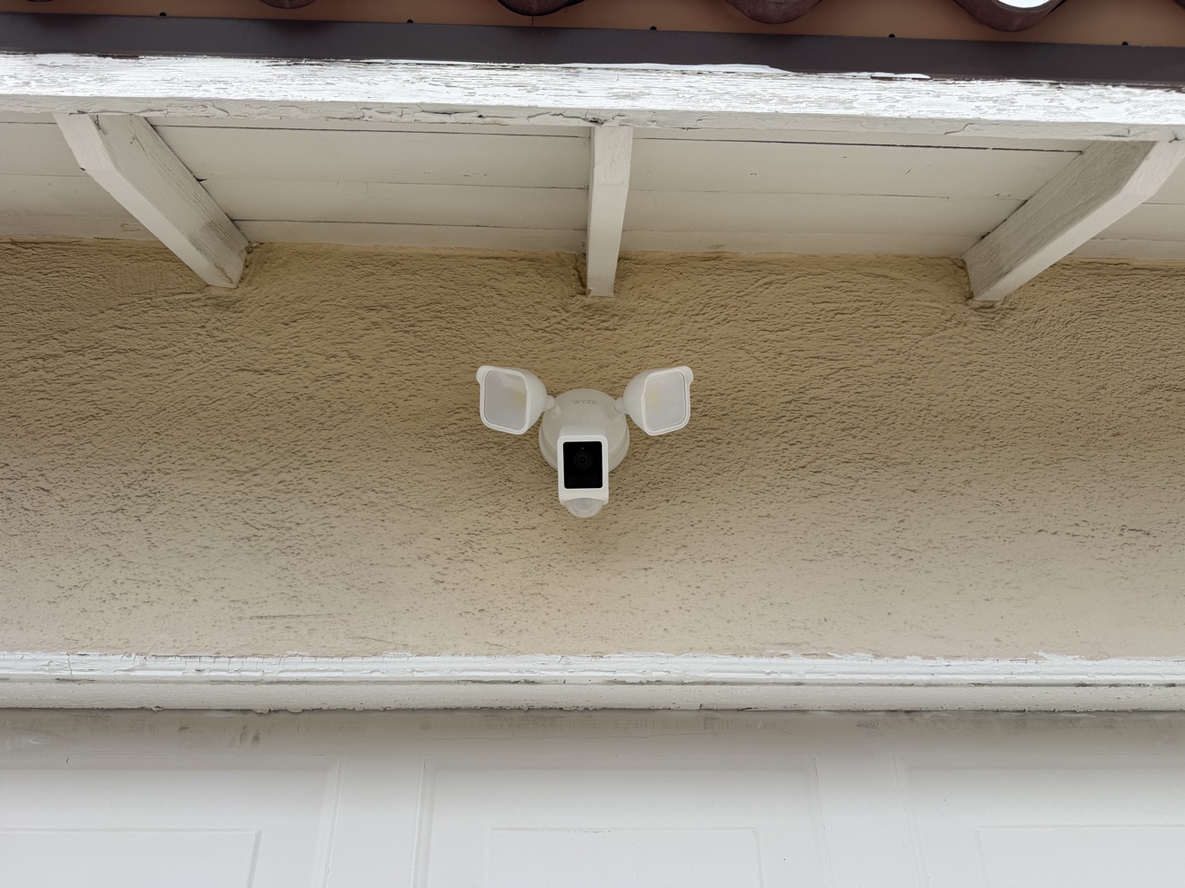 Floodlight security camera installed under roof eave