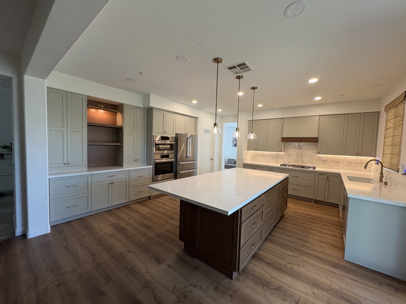Full kitchen lighting with recessed lights and pendants